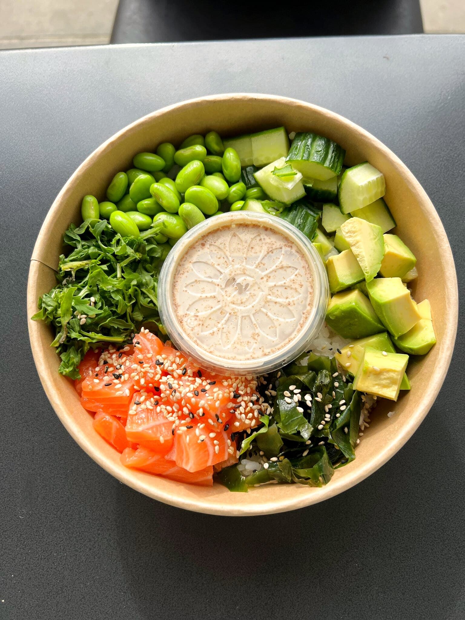 Poke Bowl von oben mit Lachs, Edamame, Avocado, Gurke und Seetang